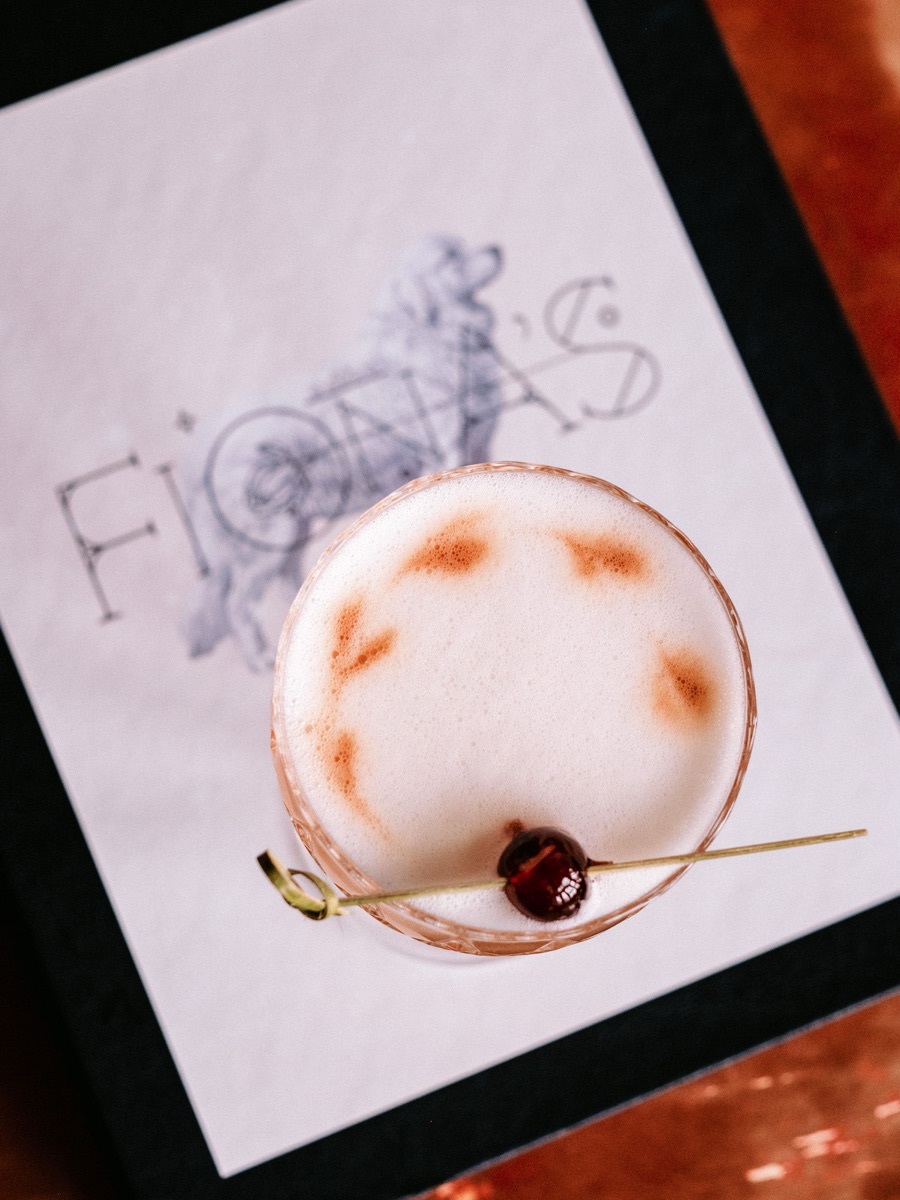 A hand-crafted cocktail on a Fiona's napkin, viewed from above